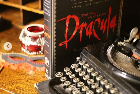 old typewriter and illustrated Dracula book with red candle