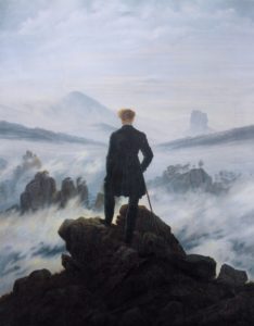 man looks out from the top of a hill