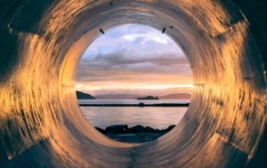 body of water seen through pipe by the sea