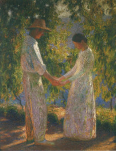 two lovers hold hands in a garden
