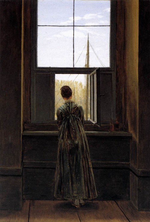 woman looks out window