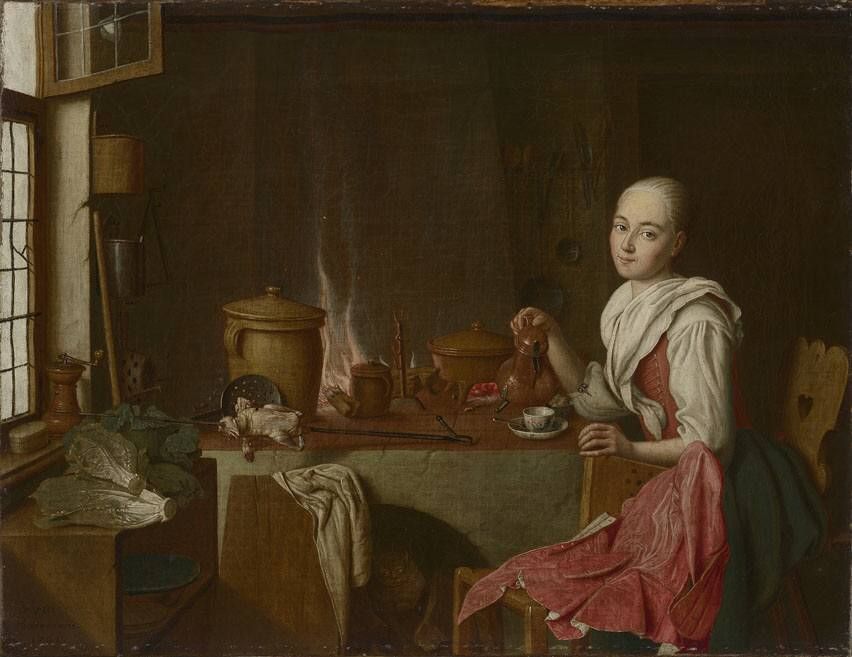 woman sits at a table pouring coffee