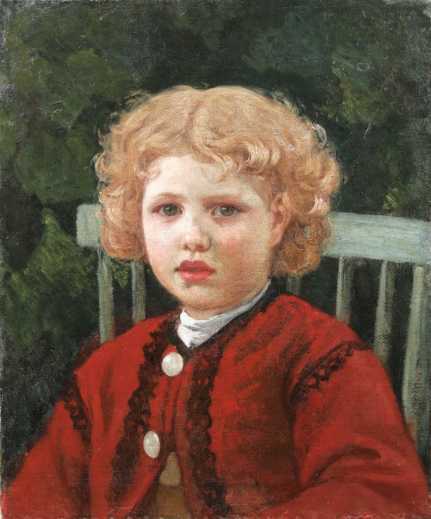 a little girl with blonde curly hair and in a red coat sits in a garden 