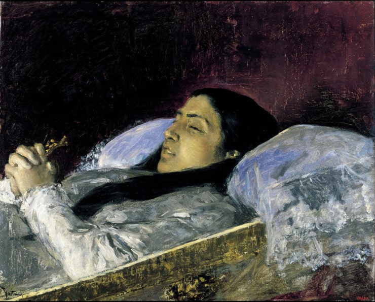woman on her deathbed holds a crucifix 